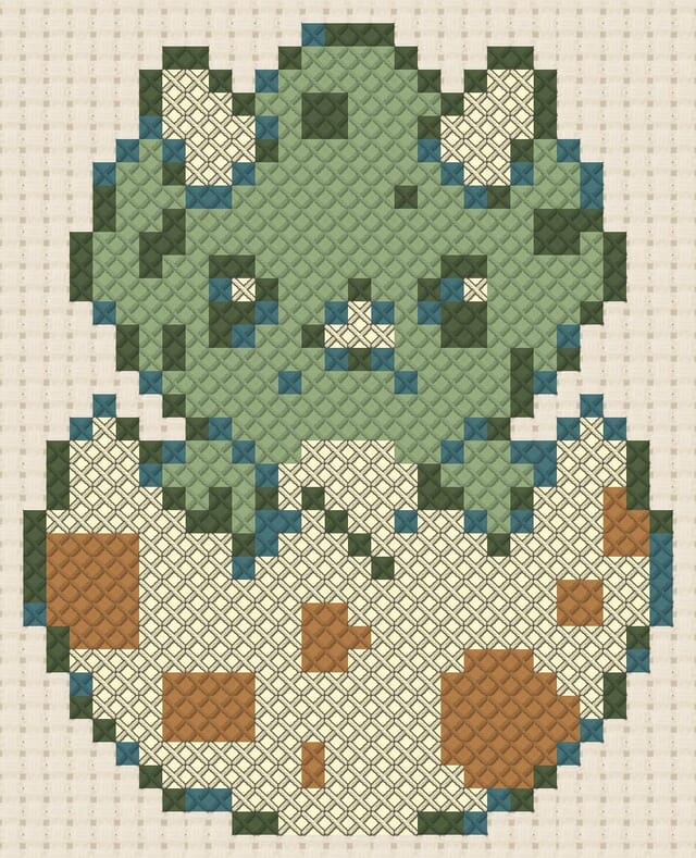 Dino egg cracking finished in cross stitch on Aida cloth
