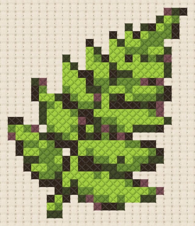 Fern frond finished in cross stitch on Aida cloth