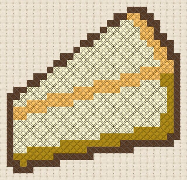 Slice of cheesecake finished in cross stitch on Aida cloth