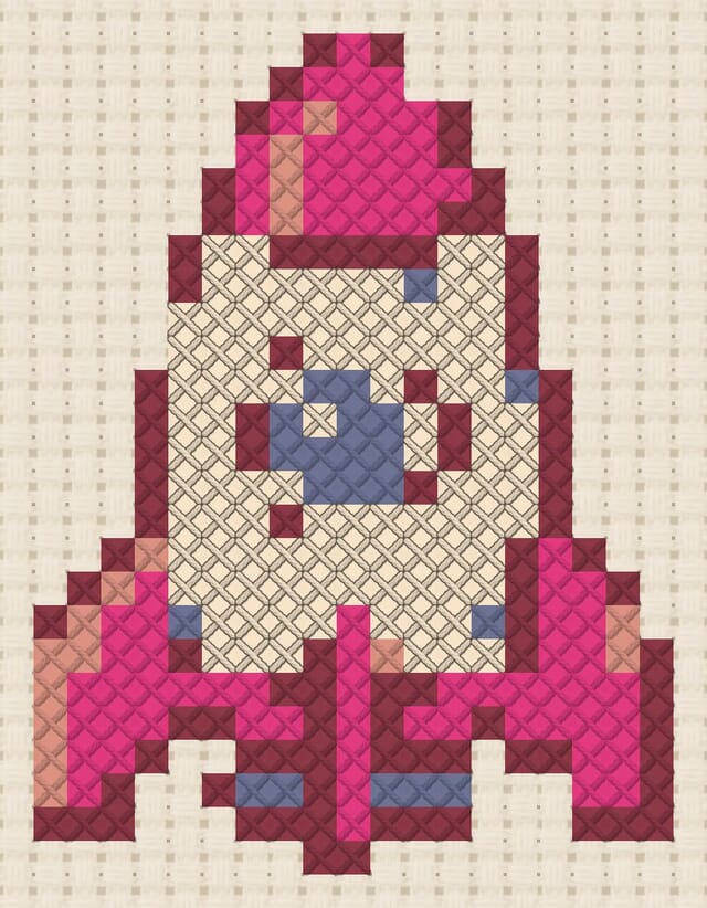 Tin rocket toy finished in cross stitch on Aida cloth